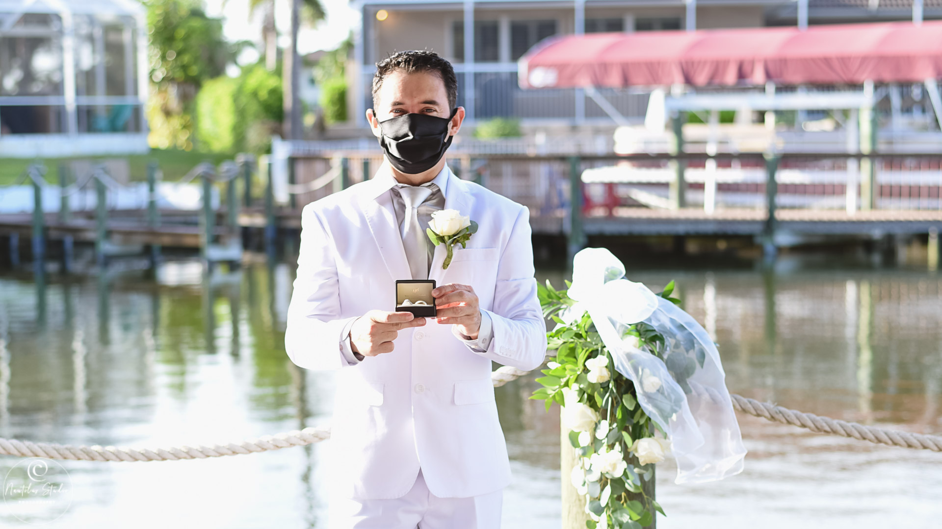Foto von Hochzeit während COVID 19 zeigt Bräutigam mit Maske und Eheringe