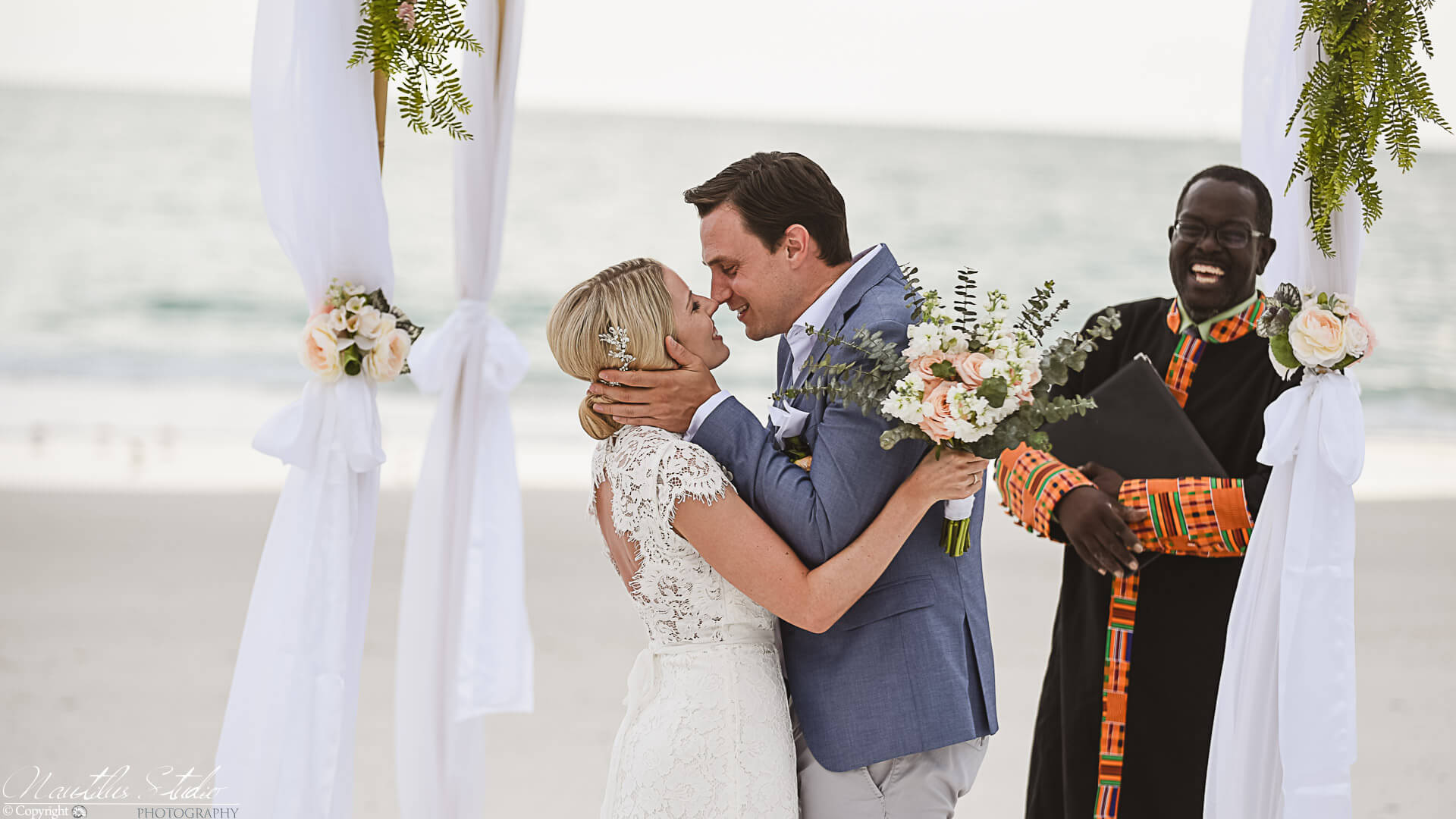 Standesbeamter in Florida, Brautpaar küsst sich unter dem Hochzeitsbogen
