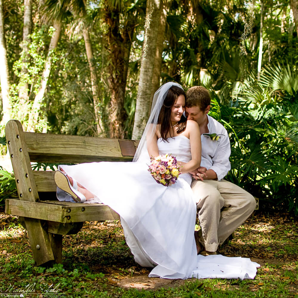 Heiraten im Park in Florida, Bild vom Brautpaar auf der Parkbank unter Bäumen.