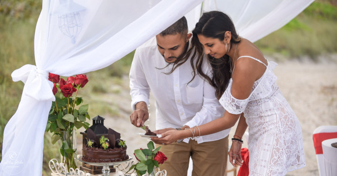 Foto vom frisch Verlobten Paar das den Kuchen anschneidet