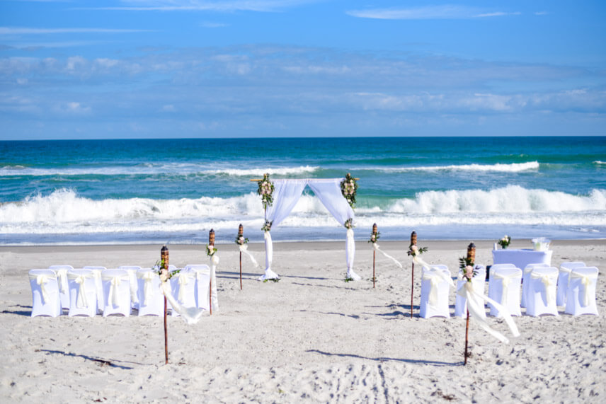 Foto von Lifestyle Hochzeit am Strand in Florida mit Hochzeitsbogen und Stuehlen