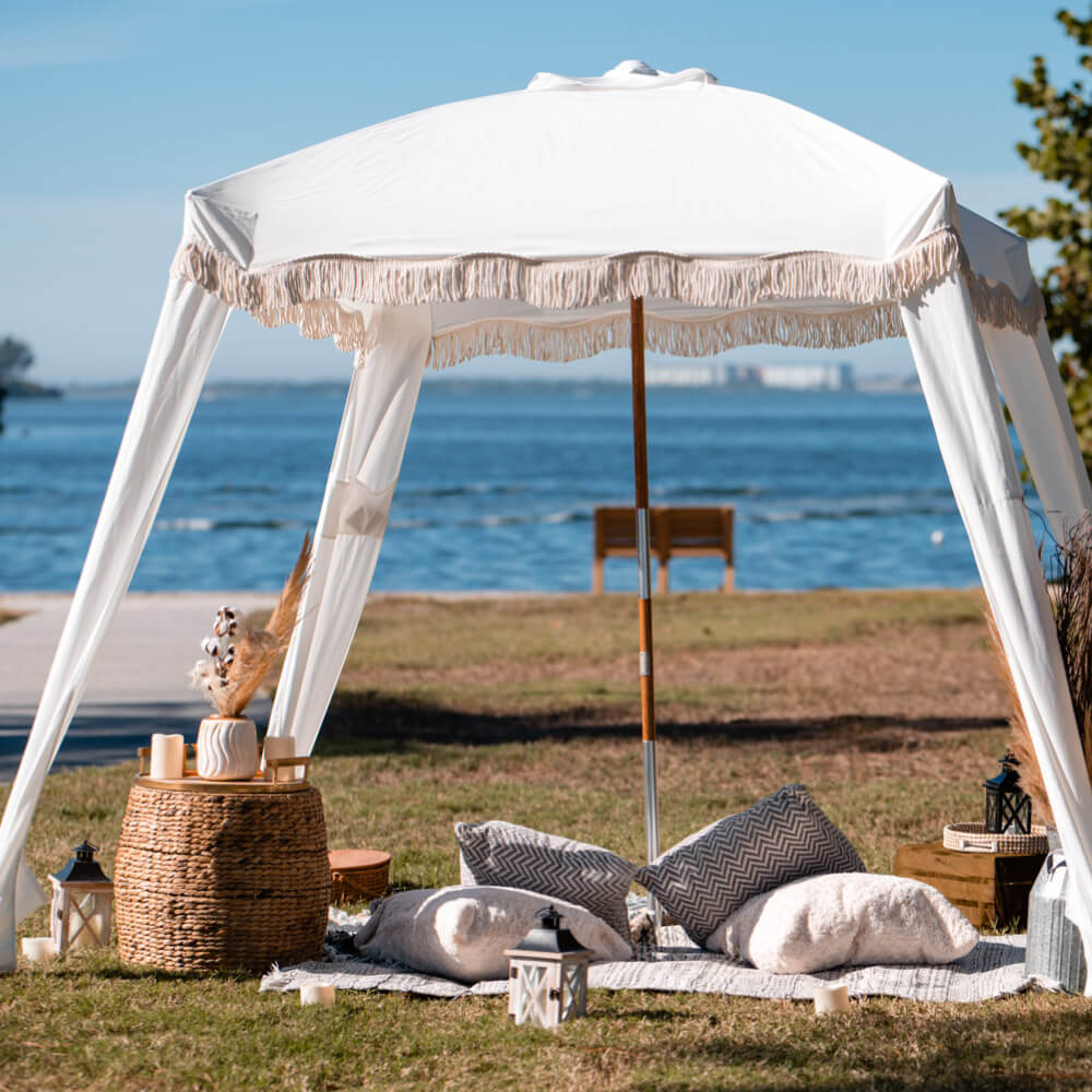Boho Cabana Heiratsantrag in Florida. Foto zeigt weisse Cabana und decorierten Picknick Platz am Meer