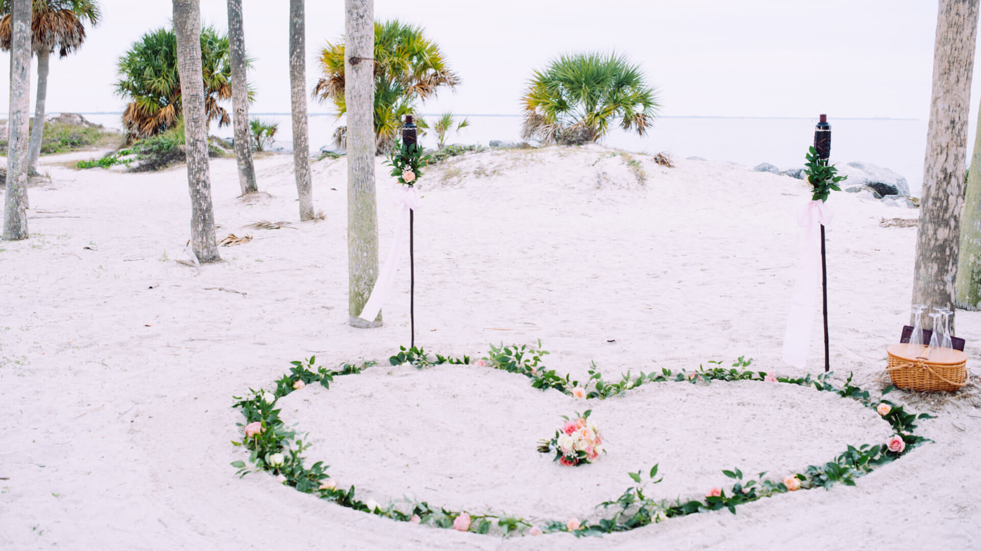 Einfach und minimalistisches Hochzeitspaket in Florida. Foto zeigt die Dekoration mit Herz im Sand aus Schnittblumen am Strand in Tarpon Springs.